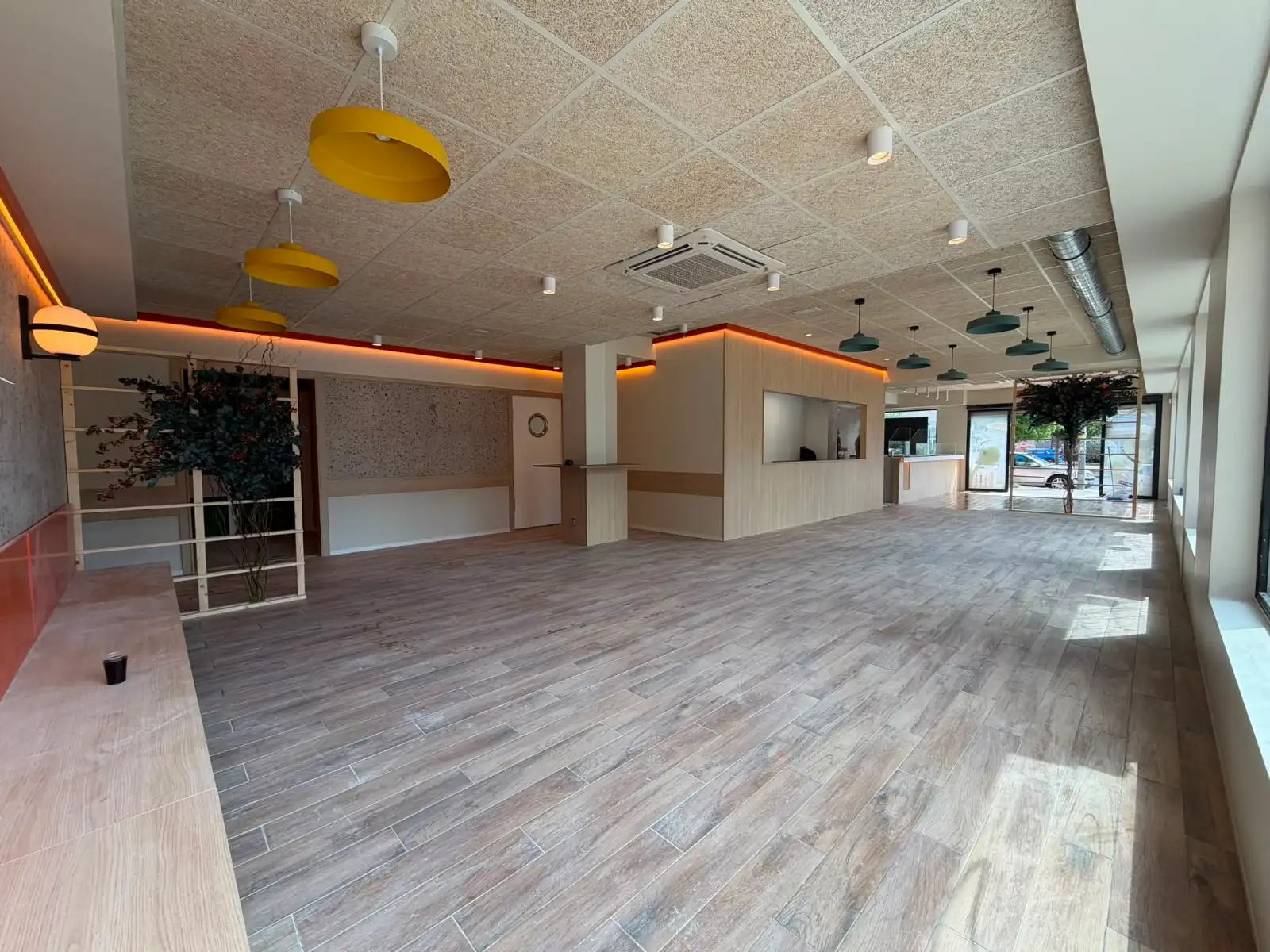 Reforma integral de local comercial con suelo porcelánico imitación madera y techo técnico en Madrid